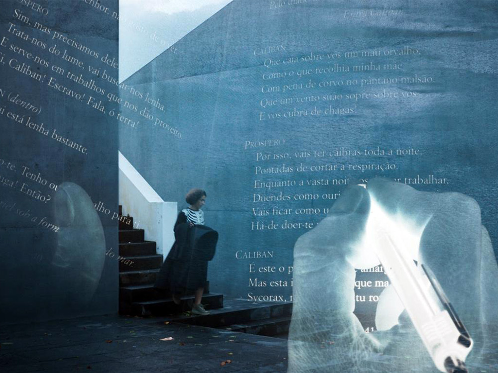 A graphic of a blue/overexposed hand writing over old Spanish text. In the background, faded, a person walks down a staircase amongst a concrete building