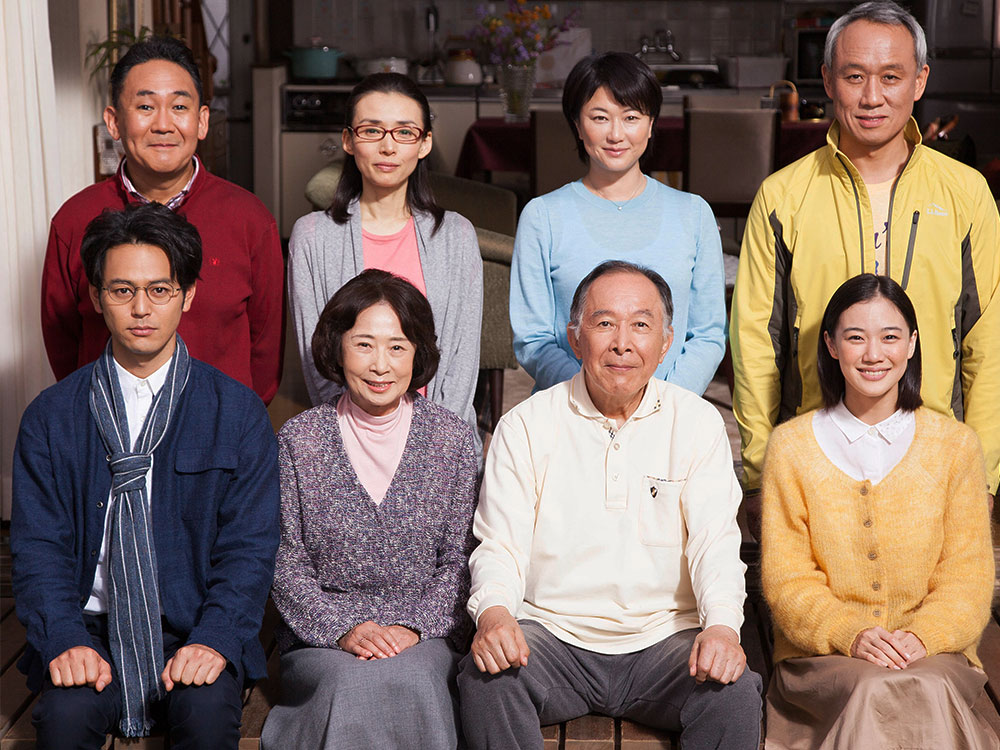 A family portrait spanning generations, each person with wide smiles