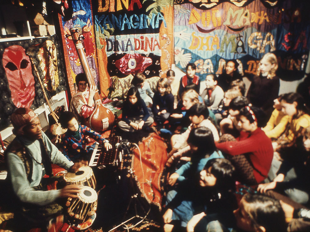 Pictured: Don, Moki and Eagle-Eye Cherry at a children’s workshop surrounded by tapestries by Moki. Courtesy: Cherry Archive, Estate of Moki Cherry.