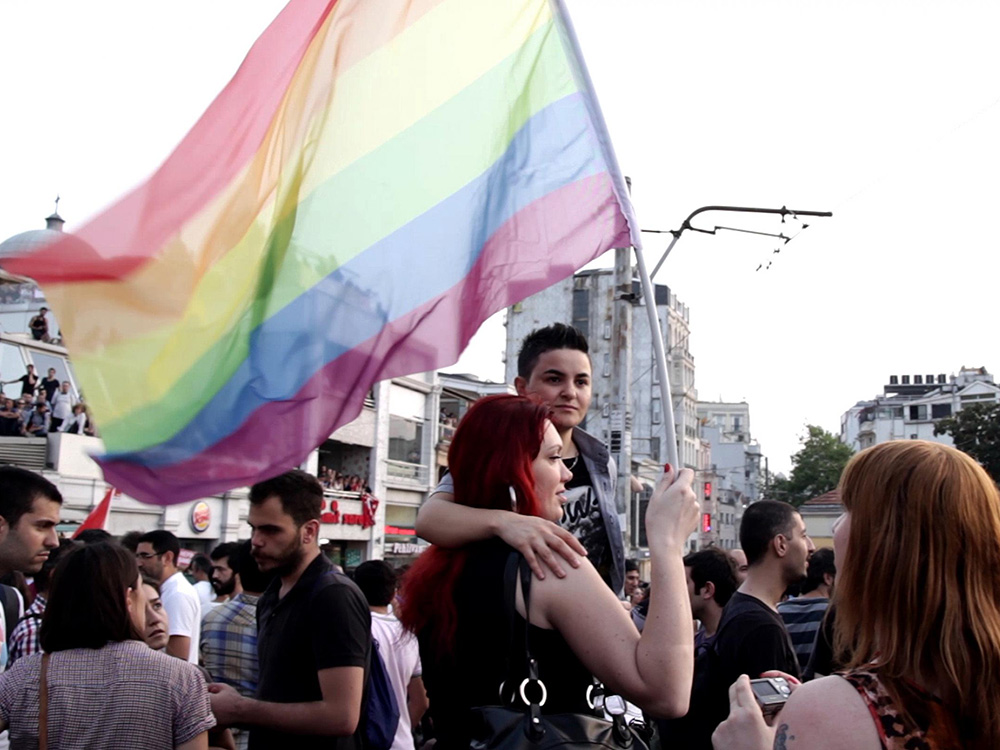 A couple hold a rainbow flag at the 21st Istanbul LGBTI Pride parades