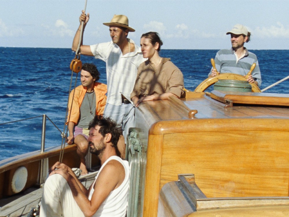 A group of young people in holiday clothes sail a fancy wooden ship