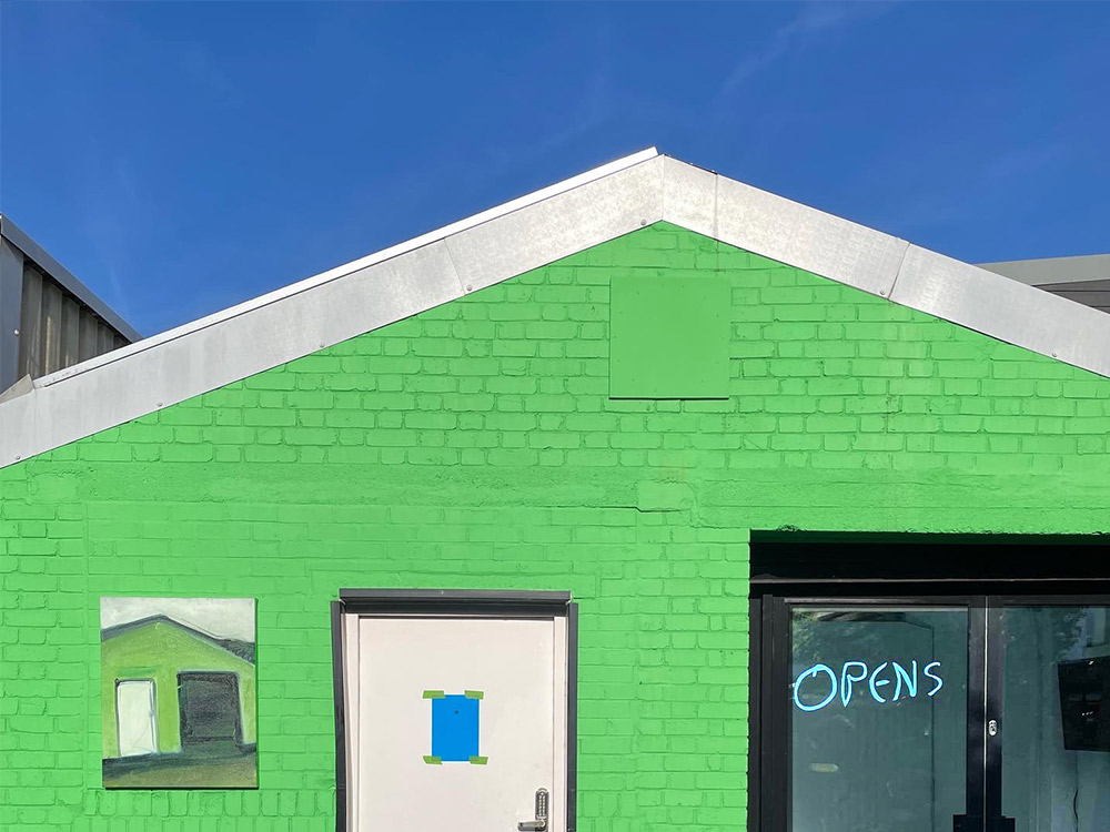 The Conditions studio, a green building, and a bright blue sky